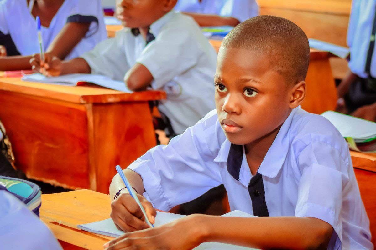 A student writing at a school desk