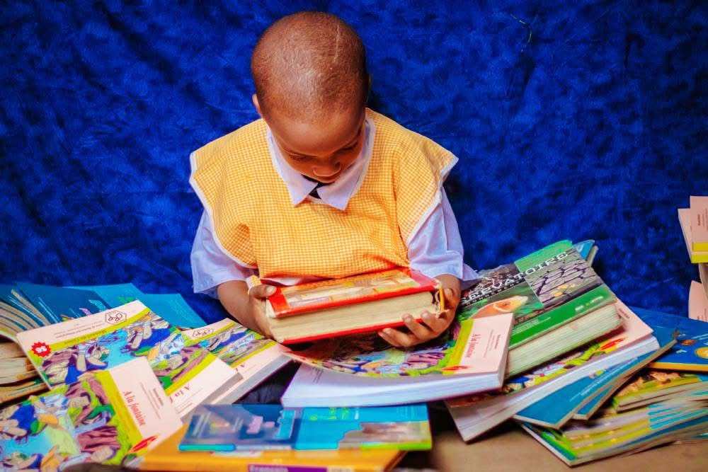 A child reading among a pile of books