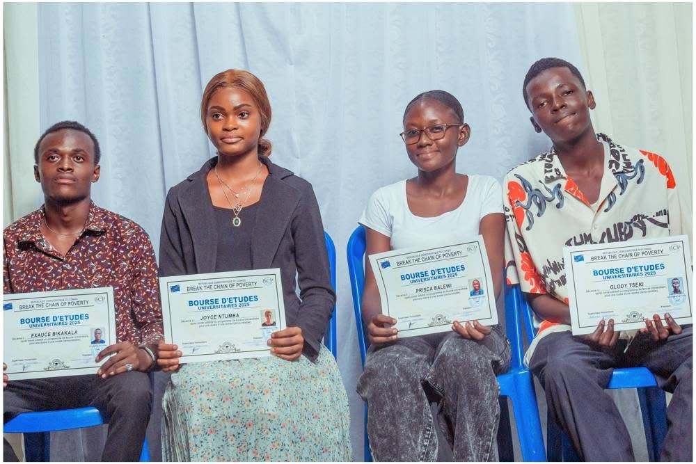 Four people holding university scholarship certificates
